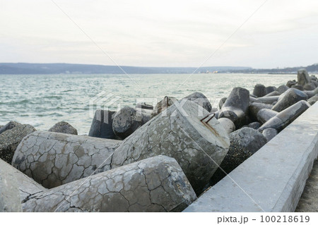 View from the Diga Sottomarina pier. Concrete breakwater with the blue sea background meeting the horizon. Seascape. View from the Diga Sottomarina pier. Concrete breakwater with the blue sea background meeting the horizon. Seascape. 100218619