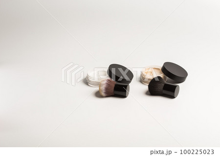 Mineral makeup powder twist seal sifter isolated on white background with brush copy space. Many beige foundation powder. Skin tone face cosmetic product sample Mineral makeup powder twist seal sifter isolated on white background with brush copy space. Many beige foundation powder. Skin tone face cosmetic product sample 100225023