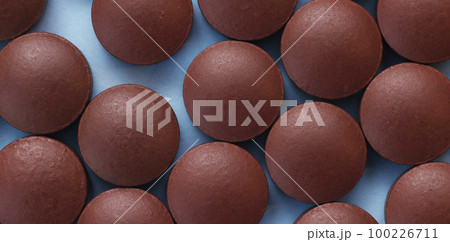 Brown pills on a blue background top view. Brown pills on a blue background top view. 100226711