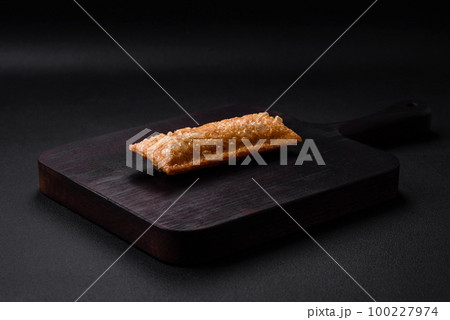Delicious fresh crispy pie with cherry jam on a wooden cutting board 100227974
