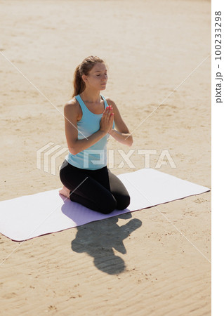 yoga, woman do meditation on seashore in morning. fitness millennial female trains 100233298