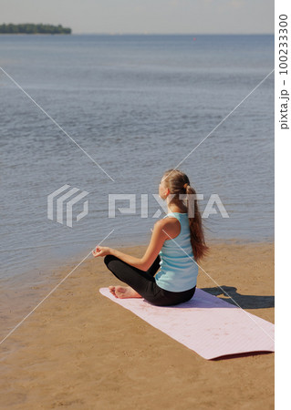 yoga, woman do meditation on seashore in morning. fitness millennial female trains 100233300