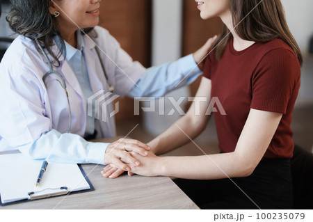 Portrait of a female doctor holding a patient's hand to encourage the fight against disease Portrait of a female doctor holding a patient's hand to encourage the fight against disease 100235079