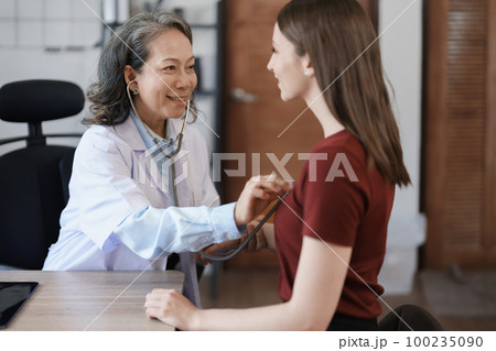 Portrait of a female doctor using a stethoscope to check the pulse of an elderly patient Portrait of a female doctor using a stethoscope to check the pulse of an elderly patient 100235090