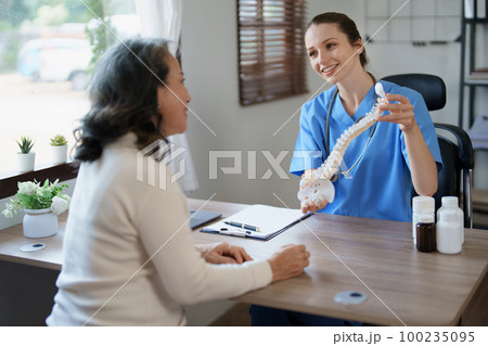 Portrait of a female doctor talking to an elderly patient about herniated disc deterioration from long hours of work Portrait of a female doctor talking to an elderly patient about herniated disc deterioration from long hours of work 100235095