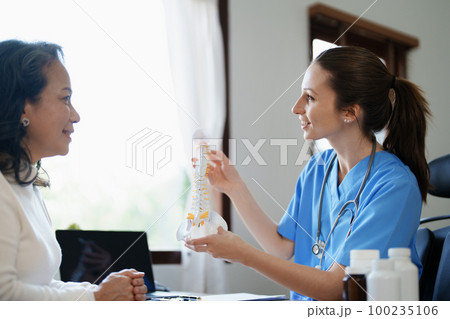 Portrait of a female doctor talking to an elderly patient about herniated disc deterioration from long hours of work Portrait of a female doctor talking to an elderly patient about herniated disc deterioration from long hours of work 100235106
