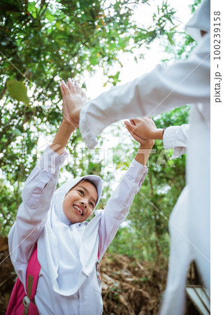 two female elementary students playing together happily 100239158