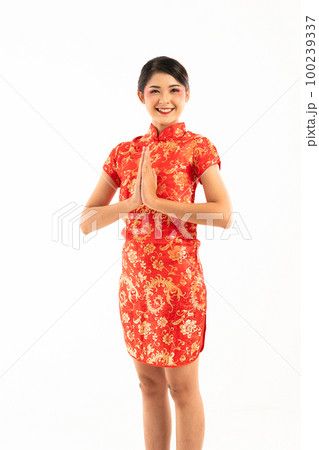 beautiful asian woman in red cheongsam standing put hands together 100239337