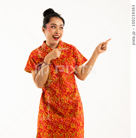 asian woman in cheongsam standing pointed to her left side asian woman in cheongsam standing pointed to her left side 100239363