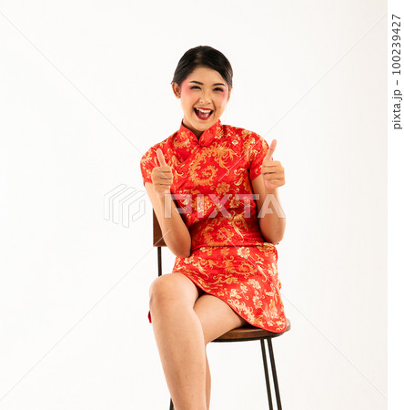 a beautiful asian women in red cheongsam sitting with thumbs up a beautiful asian women in red cheongsam sitting with thumbs up 100239427