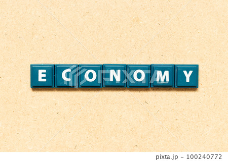 Tile alphabet letter in word economy on wood background 100240772