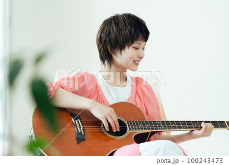 ギターを弾く若い女性 100243473