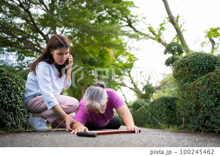 Asian senior woman fell down on lying floor because faint and limb weakness and pain from accident and woman came to help support and call emergency. Concept of old elderly insurance and health care Asian senior woman fell down on lying floor because faint and limb weakness and pain from accident and woman came to help support and call emergency. Concept of old elderly insurance and health care 100245462