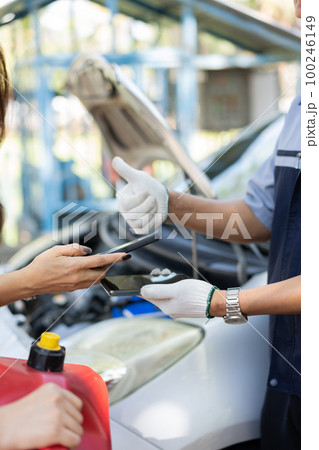 Asian women get contact numbers from auto mechanics after fixing the car engine problem and QR code scan to pay for gas after running out of fuel on the road. Car repair and maintenance concept. Asian women get contact numbers from auto mechanics after fixing the car engine problem and QR code scan to pay for gas after running out of fuel on the road. Car repair and maintenance concept. 100246149