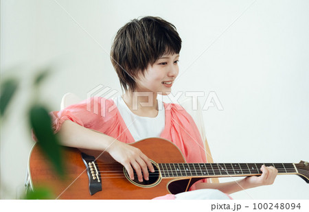 ギターを弾く若い女性 100248094