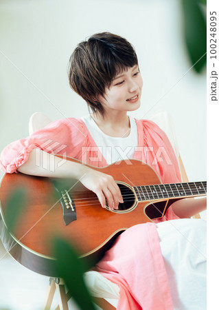 ギターを弾く若い女性 100248095