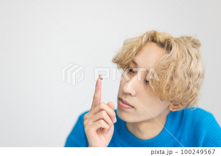 コンタクトレンズを装着する男性 100249567