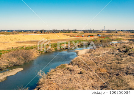 河川敷の築堤工事 入間川流域河川敷 川面と重機とダンプ 2023.02　b-3 暖色寒色強調 100250084