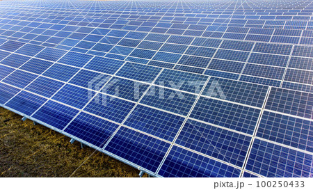 Aerial drone view flight over solar power station panels. Aerial top view of solar farm. Green energy, electrical innovation. Renewable Energy. Industrial Solar Energy Farm producing solar power. 100250433