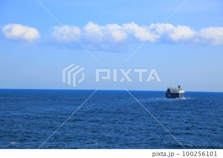 穏やかな海を静かに進む貨物船 100256101