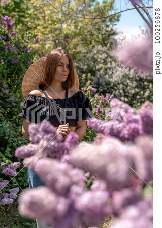 portrait of young woman with long hair outdoors in blooming lilac garden portrait of young woman with long hair outdoors in blooming lilac garden 100256878