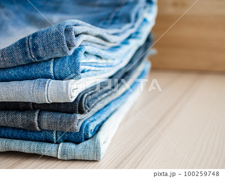 denim blue jeans stack on wood table background 100259748