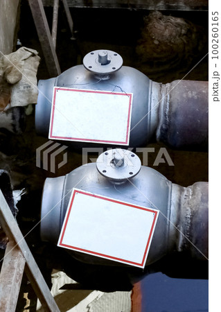 Insulated pipes for hot water and valve underground closeup 100260165