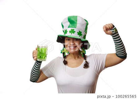 Beautiful multi-ethnic woman celebrating Saint Patrick's pub party, holding a mug with traditional Irish alcohol drink - green beer, cheerfully smiling looking at camera, on isolated white background Beautiful multi-ethnic woman celebrating Saint Patrick's pub party, holding a mug with traditional Irish alcohol drink - green beer, cheerfully smiling looking at camera, on isolated white background 100265565