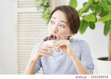 家でチョコレートを食べる女性 家でチョコレートを食べる女性 100269058