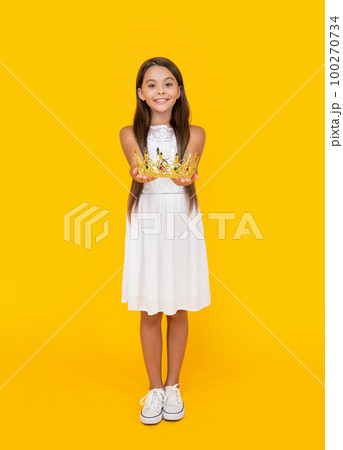 happy teen child in crown on yellow background 100270734