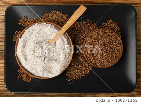 Buckwheat Flour Pile in Wood Bowl, Dry Buck Wheat Powder, Buckwheat Flour on Wooden Rustic Background 100271365