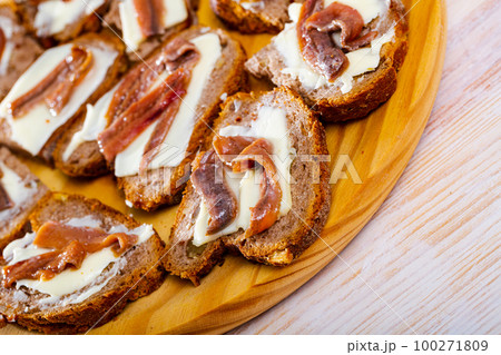 Canapes of bread with butter and salted anchovies Canapes of bread with butter and salted anchovies 100271809