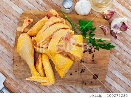 Raw chicken with condiments on kitchen table Raw chicken with condiments on kitchen table 100272286