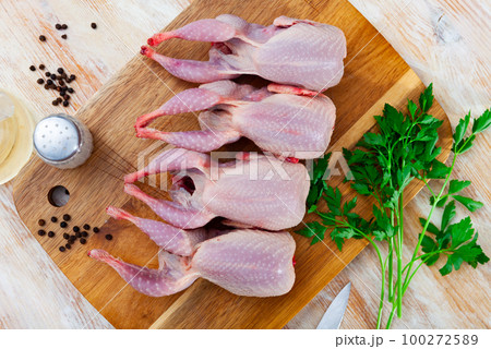 Fresh raw meat quails ready for cooking on slate board Fresh raw meat quails ready for cooking on slate board 100272589