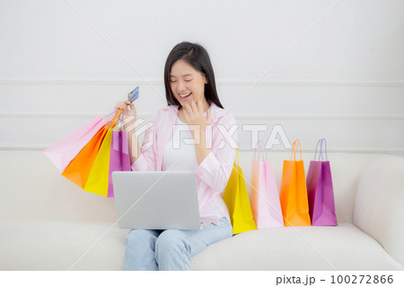 Young asian woman sitting on sofa using laptop computer shopping online. Young asian woman sitting on sofa using laptop computer shopping online. 100272866