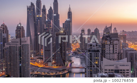 View of various skyscrapers in tallest recidential block in Dubai Marina aerial night to day timelapse View of various skyscrapers in tallest recidential block in Dubai Marina aerial night to day timelapse 100276859
