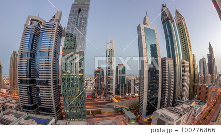 Aerial view of Dubai International Financial District with many skyscrapers night to day timelapse. Aerial view of Dubai International Financial District with many skyscrapers night to day timelapse. 100276866