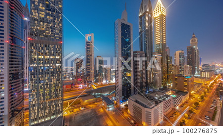 Aerial view of Dubai International Financial District with many skyscrapers day to night timelapse. 100276875