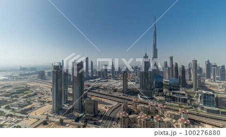 Panorama showing aerial view of tallest towers in Dubai Downtown skyline and highway timelapse. 100276880