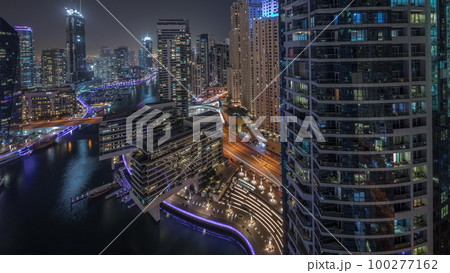 Aerial view to Dubai marina skyscrapers around canal with floating boats night timelapse Aerial view to Dubai marina skyscrapers around canal with floating boats night timelapse 100277162