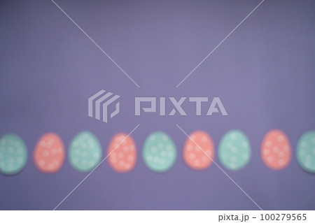 Decorated paper easter eggs and copy space for text on colored background, top view. Blurred image Decorated paper easter eggs and copy space for text on colored background, top view. Blurred image 100279565