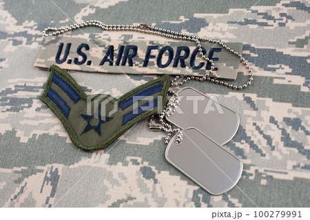 August 31, 2020. US AIR FORCE branch tape and Airman First Class rank patch and dog tags on digital tiger-stripe pattern Airman Battle Uniform (ABU) background August 31, 2020. US AIR FORCE branch tape and Airman First Class rank patch and dog tags on digital tiger-stripe pattern Airman Battle Uniform (ABU) background 100279991