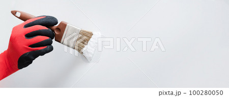 Man painting interior of home by paintbrush 100280050