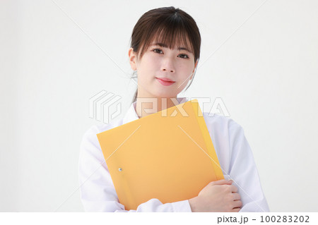 オレンジ色のファイルを持つ白衣の若い女性1 オレンジ色のファイルを持つ白衣の若い女性1 100283202