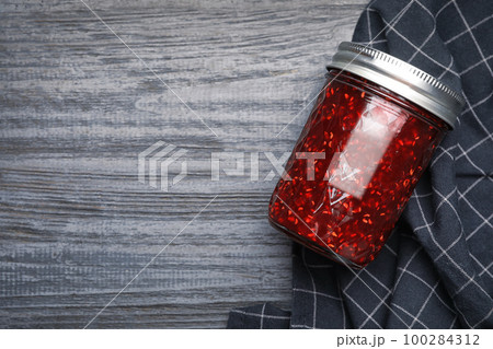 Homemade delicious raspberry jam on grey wooden table, flat lay. Space for text Homemade delicious raspberry jam on grey wooden table, flat lay. Space for text 100284312