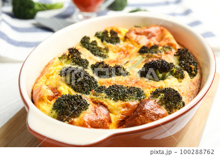 Tasty broccoli casserole in baking dish on wooden board, closeup Tasty broccoli casserole in baking dish on wooden board, closeup 100288762