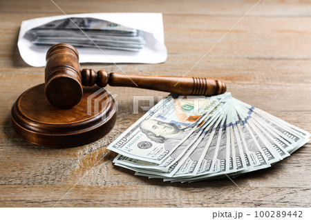 Dollar bills and gavel on wooden table. Bribe concept 100289442