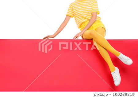 Woman wearing yellow tights sitting on color background, closeup. Space for text Woman wearing yellow tights sitting on color background, closeup. Space for text 100289819