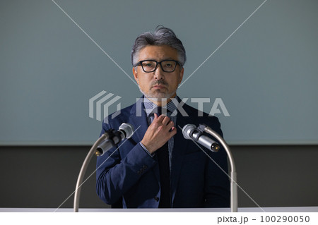 謝罪会見風のグレイヘアの男性 100290050