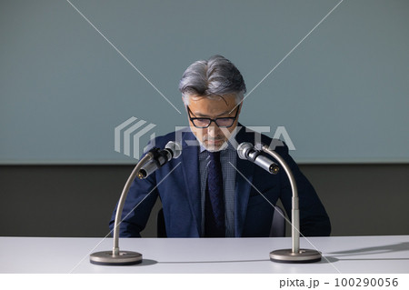 謝罪会見風のグレイヘアの男性 100290056